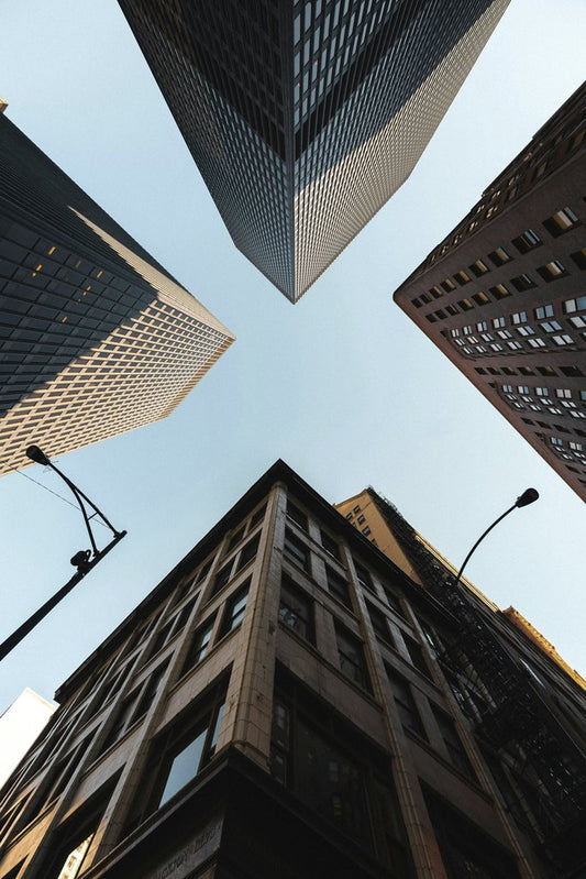 Lukas Rodriguez - Dynamic view of Chicago skyscrapers from street level, highlighting modern architecture and a clear sky.