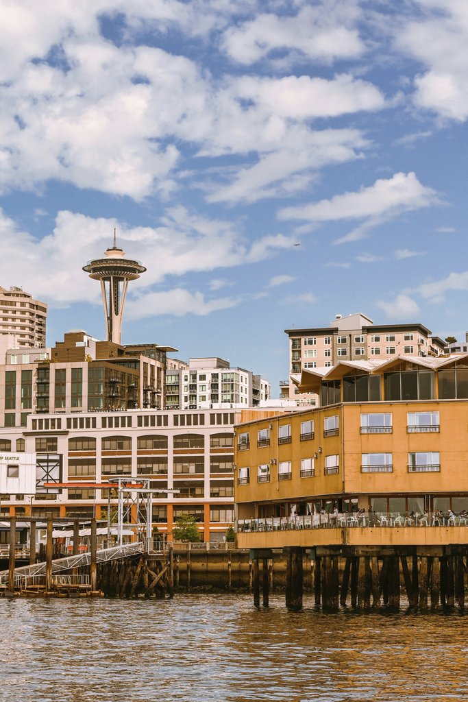 Caio - Scenic view of Seattle's iconic Space Needle from the waterfront, showcasing urban architecture.