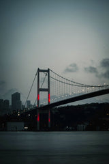 Fatih Turan - Stunning view of the Bosphorus Bridge at twilight with city skyline backdrop.