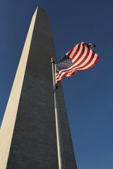 Wilson Rodriguez - Low angle view of the American flag near Washington Monument on a clear day.