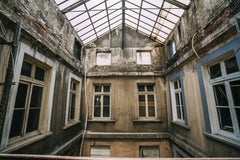 Sami TÜRK - A decaying building interior with a glass rooftop, showcasing urban decay and emptiness.
