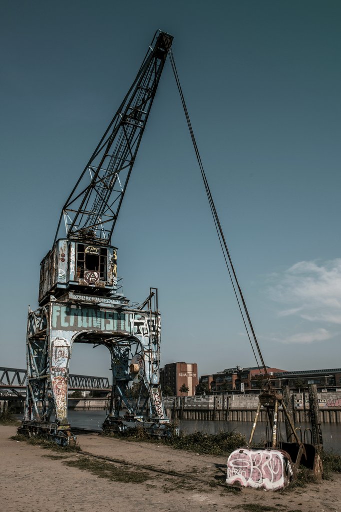Wolfgang Weiser - Vibrant graffiti on an old crane in Hamburg's scenic harbour area.