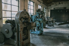 Sami TÜRK - Interior of an old factory showcasing vintage machines and equipment.