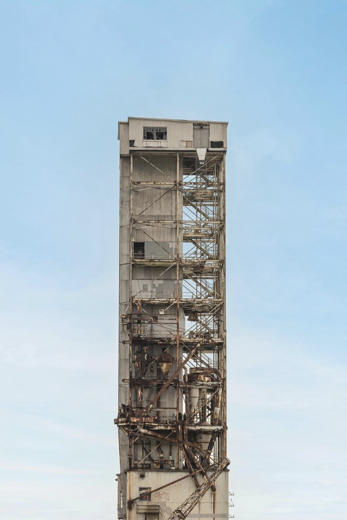 Tetyana Kovyrina - Abandoned industrial tower with rust and decay, set against a bright blue sky in Montreal, Canada.