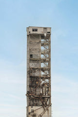 Tetyana Kovyrina - Abandoned industrial tower with rust and decay, set against a bright blue sky in Montreal, Canada.
