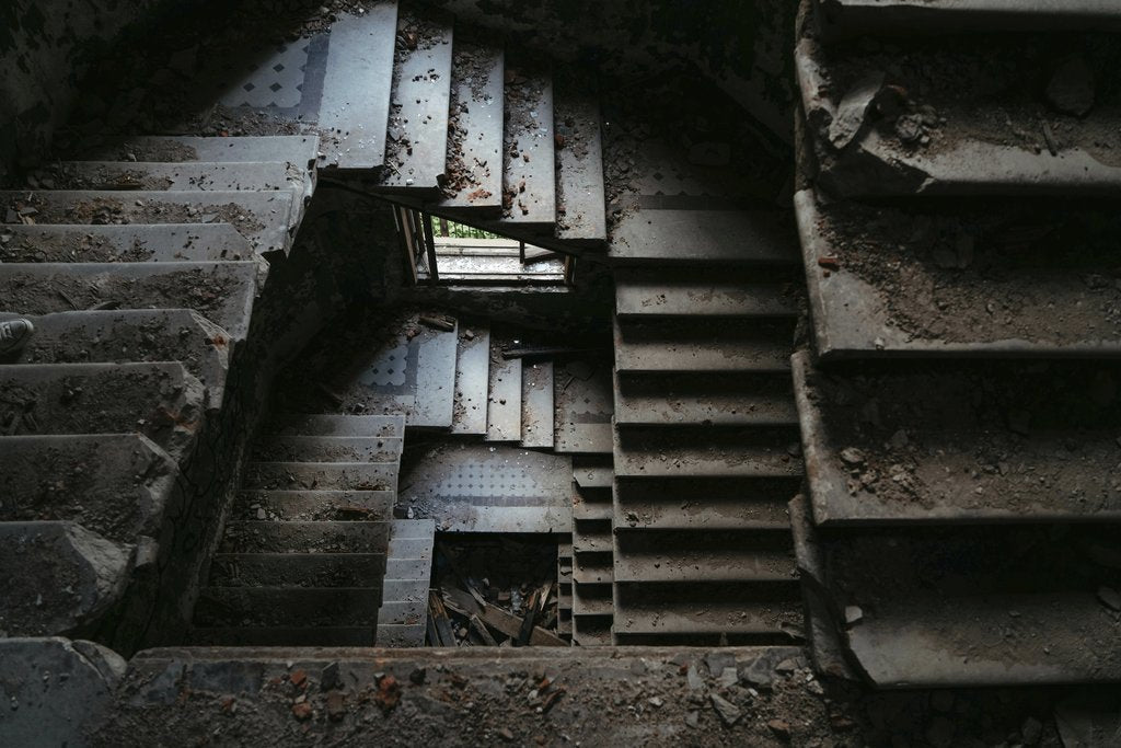 Viktor Mogilat - Explore this dramatic view of an abandoned spiral staircase in a dilapidated building.