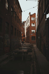 Nathan J Hilton - Discover the charm of a graffiti-lined alley with rustic brick buildings in Manchester, UK.