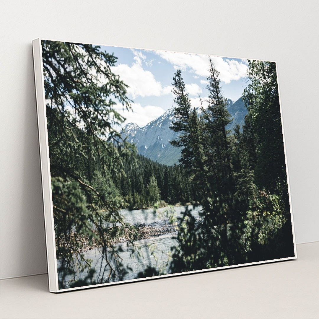 Snow-Capped Rocky Mountains and Evergreen Forest by River in Banff by Ali Kazal - White Frame Stretchiez
