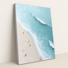 Ocean Whisper artwork features a bright beach scene with surfers carrying boards along the sand beside turquoise ocean waves, displayed in a silver frame.