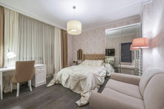 Max Vakhtbovycn - Large comfortable bed placed near table with chair in bedroom with pink furniture and walls in modern apartment