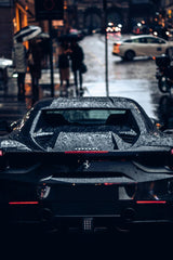 Black Ferrari in the Rainy City, sleek and wet, showcasing luxury car wall art against a rainy urban backdrop.