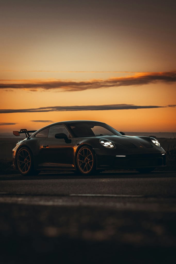 Black 911 GT3 Porsche on Open Road during sunset, sleek design and modern aesthetics for car wall art.