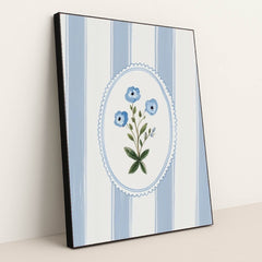 This artwork features a blue floral motif in an oval frame over vertical blue and white stripes, in a black frame.