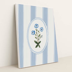 This artwork features a blue floral motif in an oval frame over vertical blue and white stripes, in a white frame.