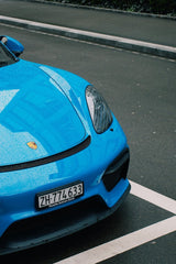 Blue Porsche 911 Resting After Rain, showcasing its vibrant color and water droplets on the hood, ideal for car wall art.