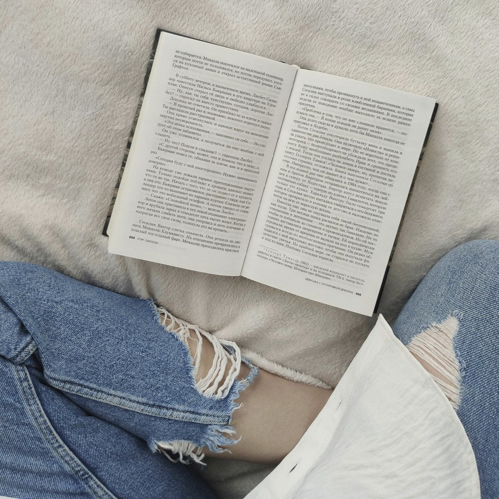 Koshevaya_k - Top view crop anonymous female wearing casual outfit sitting on comfortable soft bed with legs crossed and reading good book in free time
