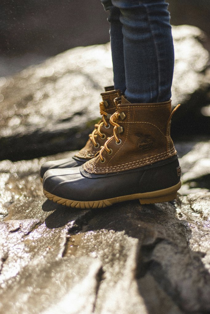 Daniel & Hannah Snipes - Close-up of durable boots on rocks, perfect for outdoor adventures.