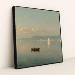 Peaceful lake scene with a rowboat and distant sailboats, soft sky, and mountains, in a black frame.