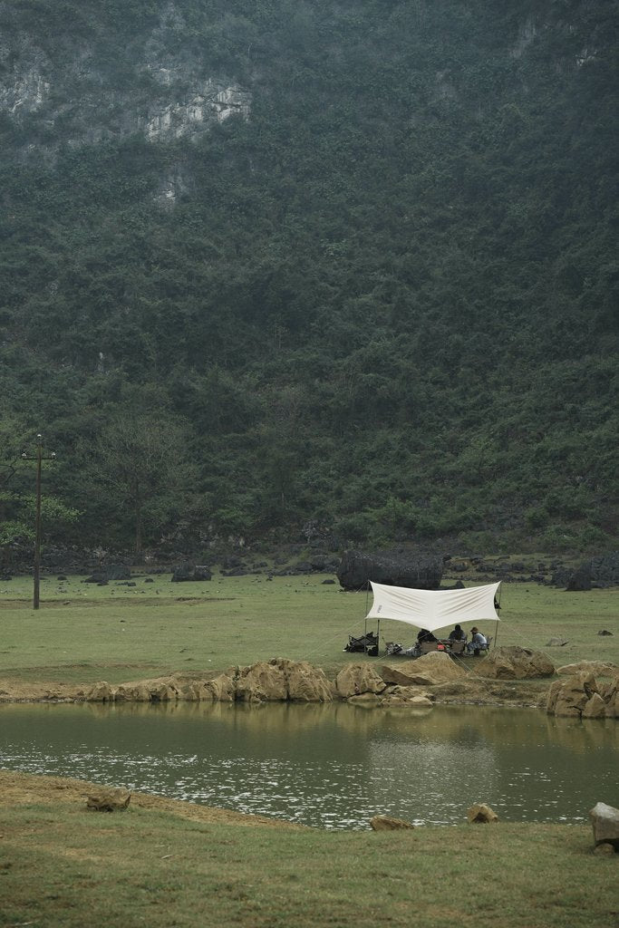 wei wei - Tranquil camping setup by a serene lake surrounded by lush misty mountains.