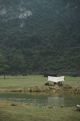 wei wei - Tranquil camping setup by a serene lake surrounded by lush misty mountains.