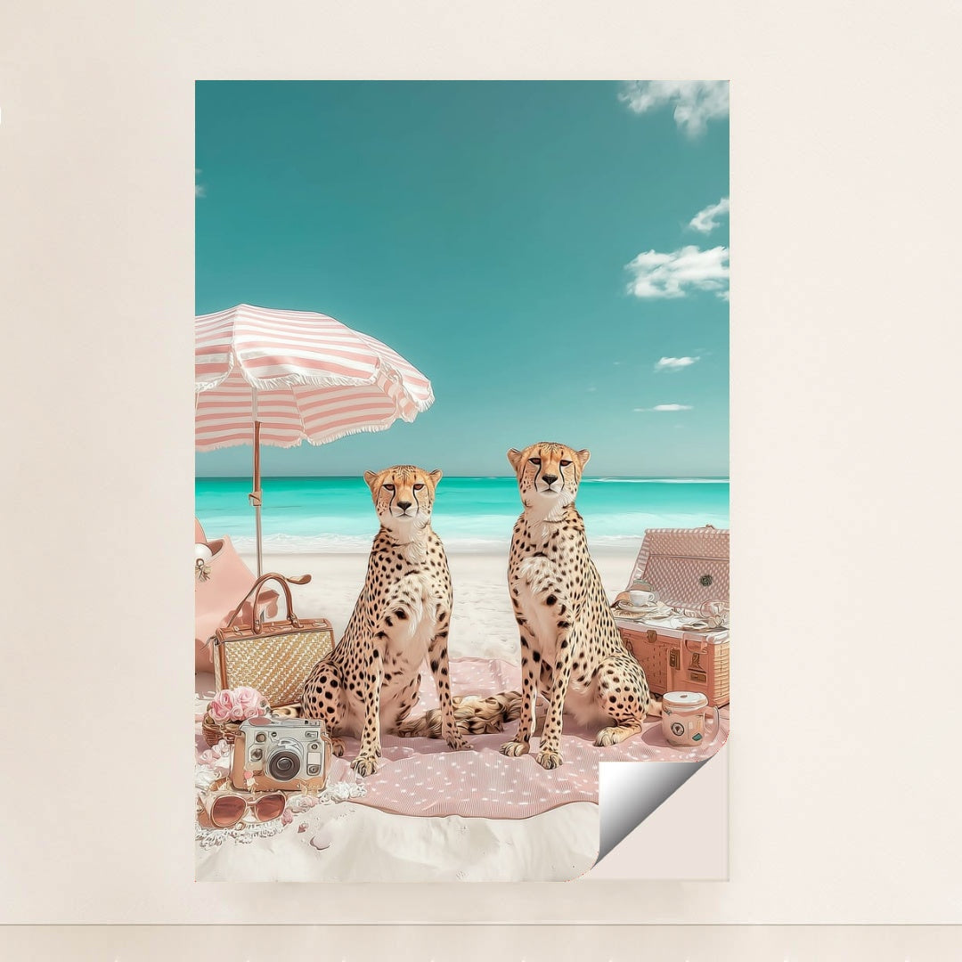 This artwork shows two cheetahs sitting on a pink picnic blanket under a striped umbrella at a bright beach, unframed.