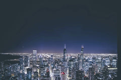 Guillermo  Arroyo - Stunning aerial view of a city skyline illuminated at night with skyscrapers and vivid lights.