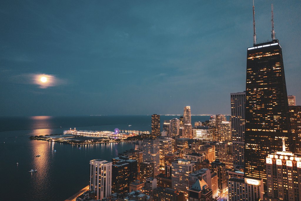 Willian Justen de Vasconcellos - Stunning aerial view of Chicago skyline under a full moon with lakefront lights.