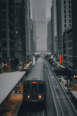Praneeth  Koduru - A train navigates through a foggy city with towering skyscrapers and urban structures, creating a moody atmosphere.