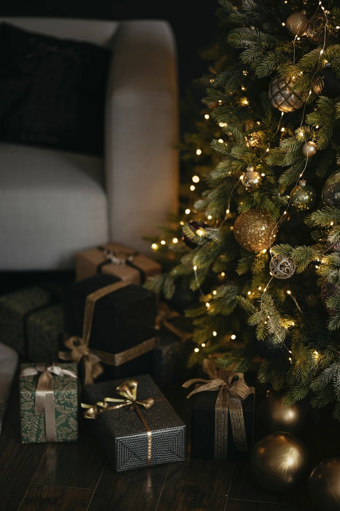 Lisett Kruusim - Cozy Christmas scene with a beautifully decorated tree and elegant wrapped presents around an armchair.