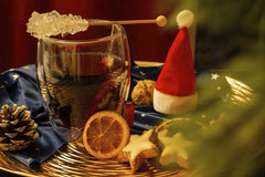 Gundula Vogel - A cozy festive setup featuring mulled wine, star cookies, and seasonal decor on a warm winter evening.