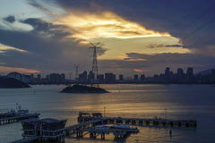 Thomas Lin - Beautiful sunset over city skyline with pier and power towers.