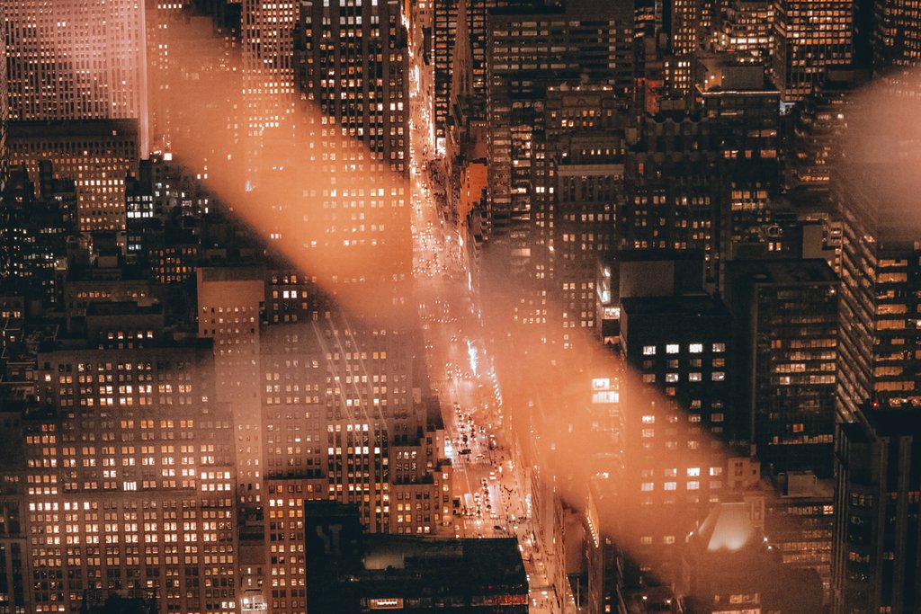 Sebastiaan Stam - A breathtaking aerial shot of New York City's skyscrapers illuminated at night.