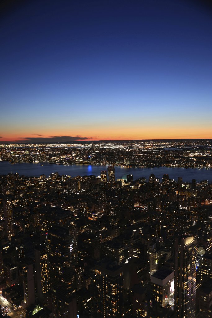 Kendrick Chen - A breathtaking aerial view of New York City's illuminated skyline at twilight, showcasing urban beauty.
