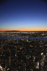 Kendrick Chen - A breathtaking aerial view of New York City's illuminated skyline at twilight, showcasing urban beauty.