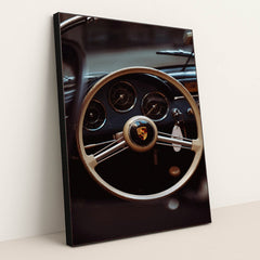 This photo shows the vintage steering wheel and gauges of a classic Porsche car, in a black frame.