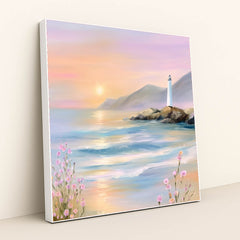 This artwork features a pastel seascape at sunset with a lighthouse on rocky cliffs and pink wildflowers, in a white frame.