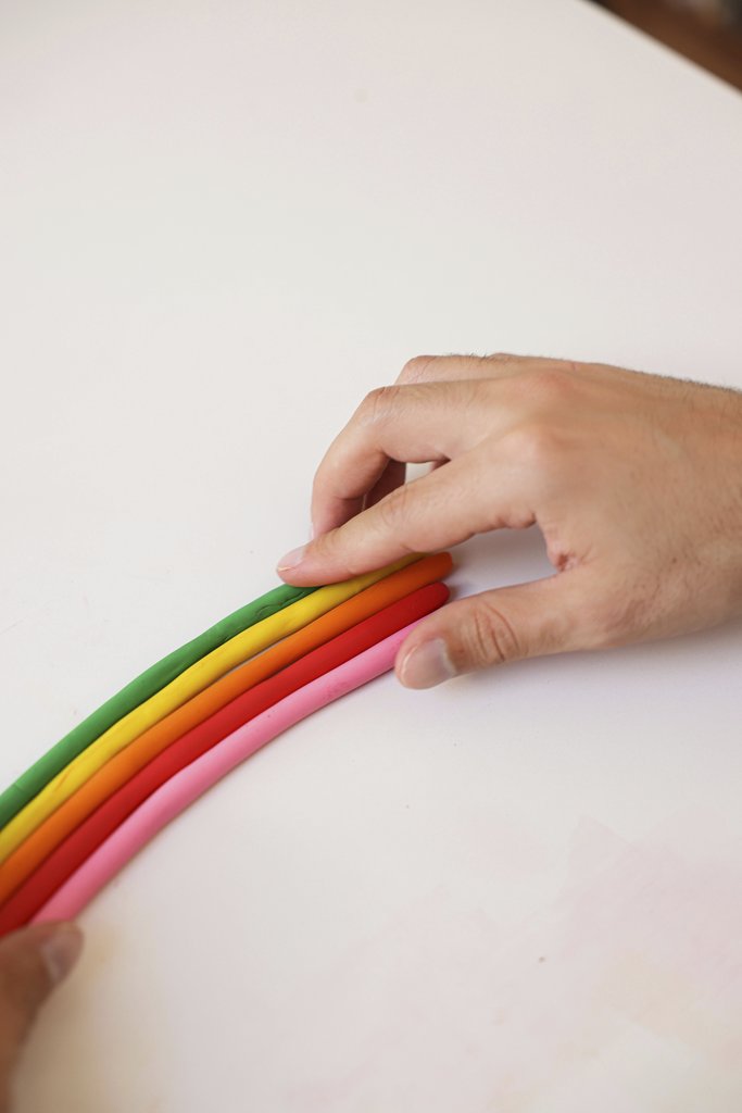 Cup of  Couple - Hands shaping a colorful clay rainbow on a white table. Bright and playful art for creativity themes.