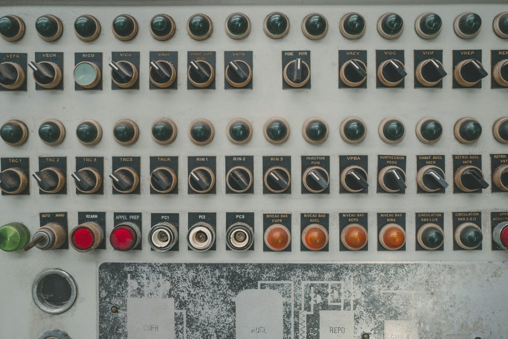 Florent Bertiaux - Close-up of a vintage industrial control panel with multiple buttons and switches.