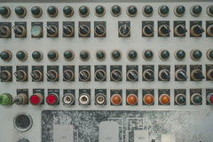 Florent Bertiaux - Close-up of a vintage industrial control panel with multiple buttons and switches.