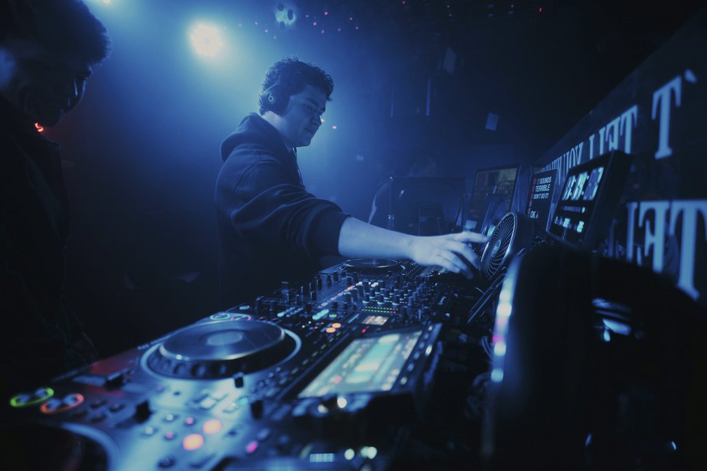 Alex Morua - DJ performing in a vibrant nightclub in León, Mexico with dynamic lighting and dance atmosphere.