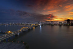Quang Nguyen Vinh - Beautiful sunset over the illuminated Dragon Bridge in Da Nang, Vietnam, highlighting the vibrant cityscape.