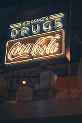 Yuqi Chen - An illuminated vintage Coca-Cola neon sign against a dark background, showcasing retro branding.