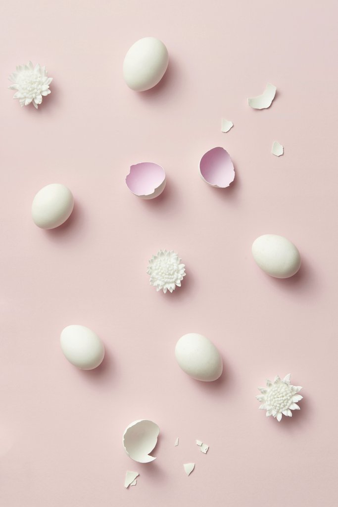 DS stories - Aesthetic flat lay with eggshells and flower accents on a pastel pink background. Perfect for Easter themes.