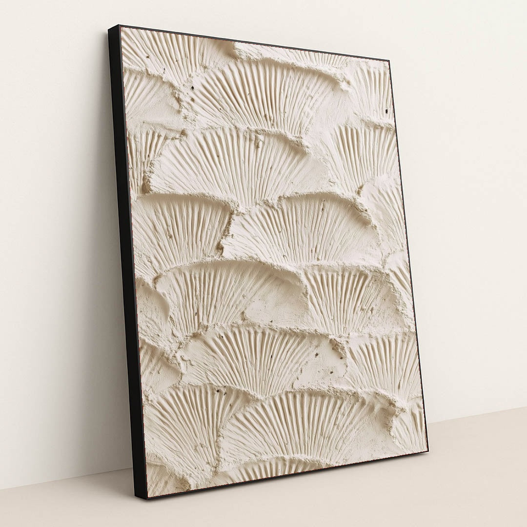 This artwork features overlapping fan-shaped textured cream plaster scales, in a black frame.