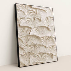 This artwork features overlapping fan-shaped textured cream plaster scales, in a black frame.