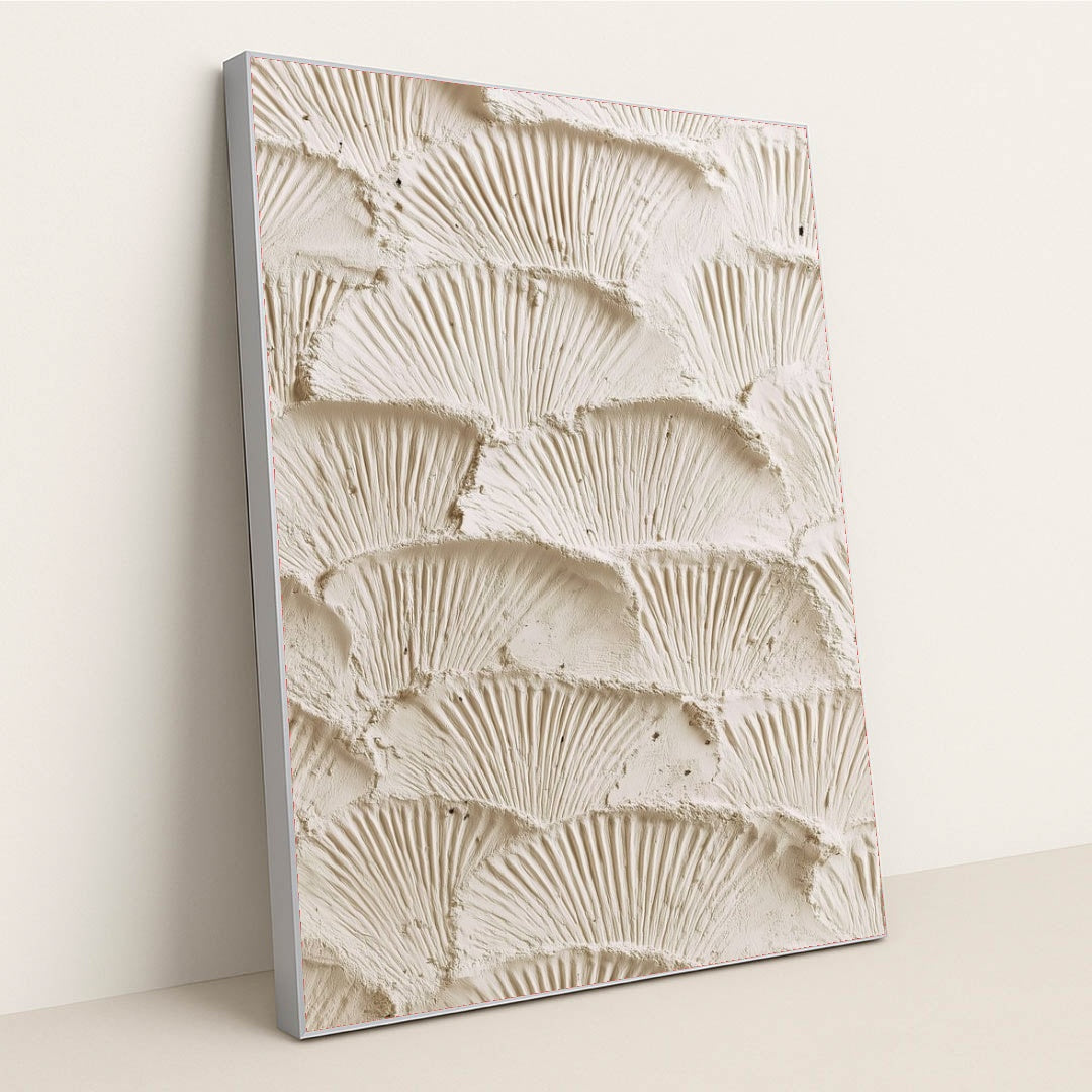 This artwork features overlapping fan-shaped textured cream plaster scales, in a silver frame.