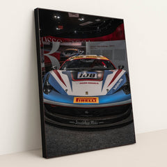 This photo shows the front view of a Ferrari 458 Challenge race car with Iron Dames and Pirelli branding in a museum, in a black frame.