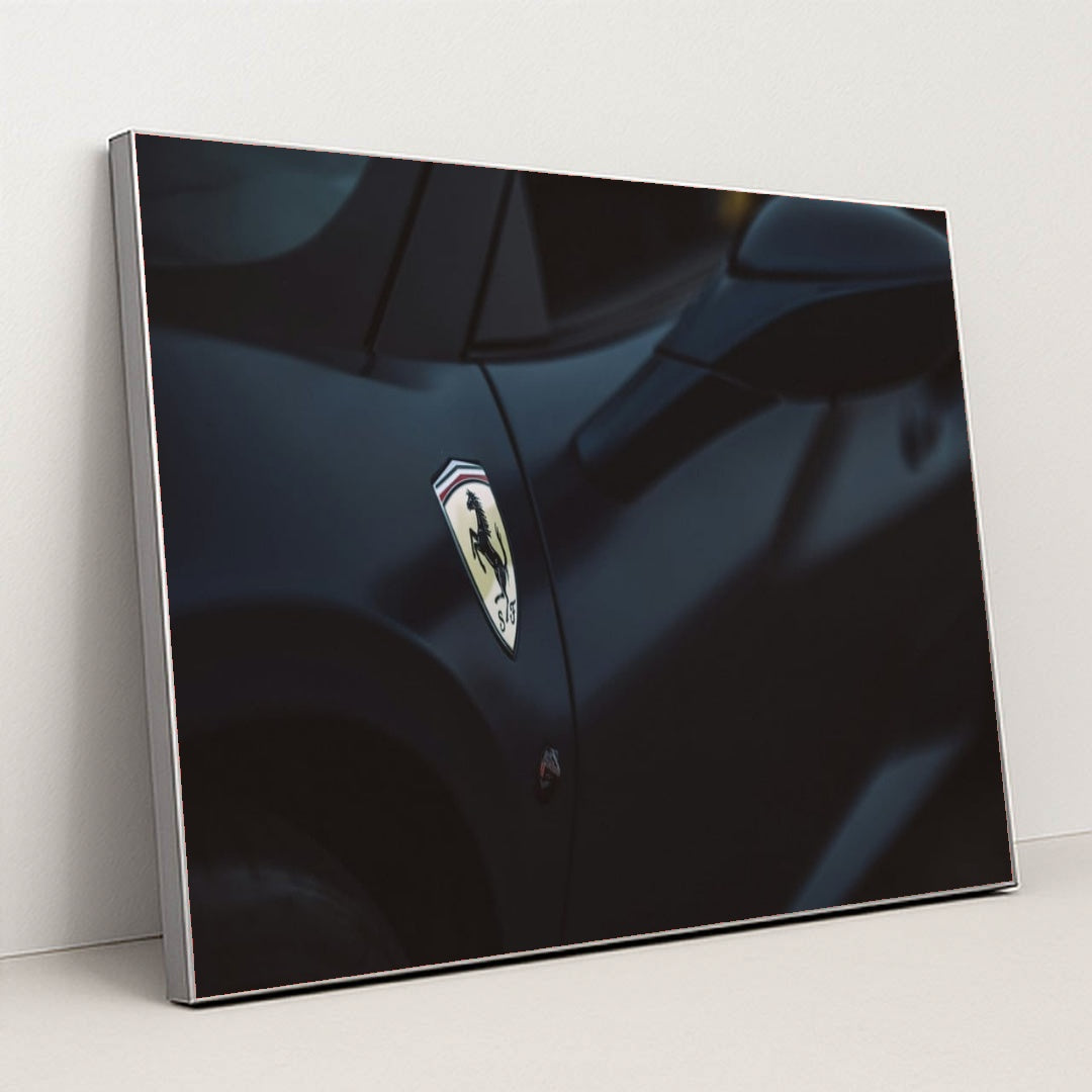 This photo shows a close-up of a dark blue Ferrari's front fender and side mirror with the Prancing Horse badge, in a silver frame.