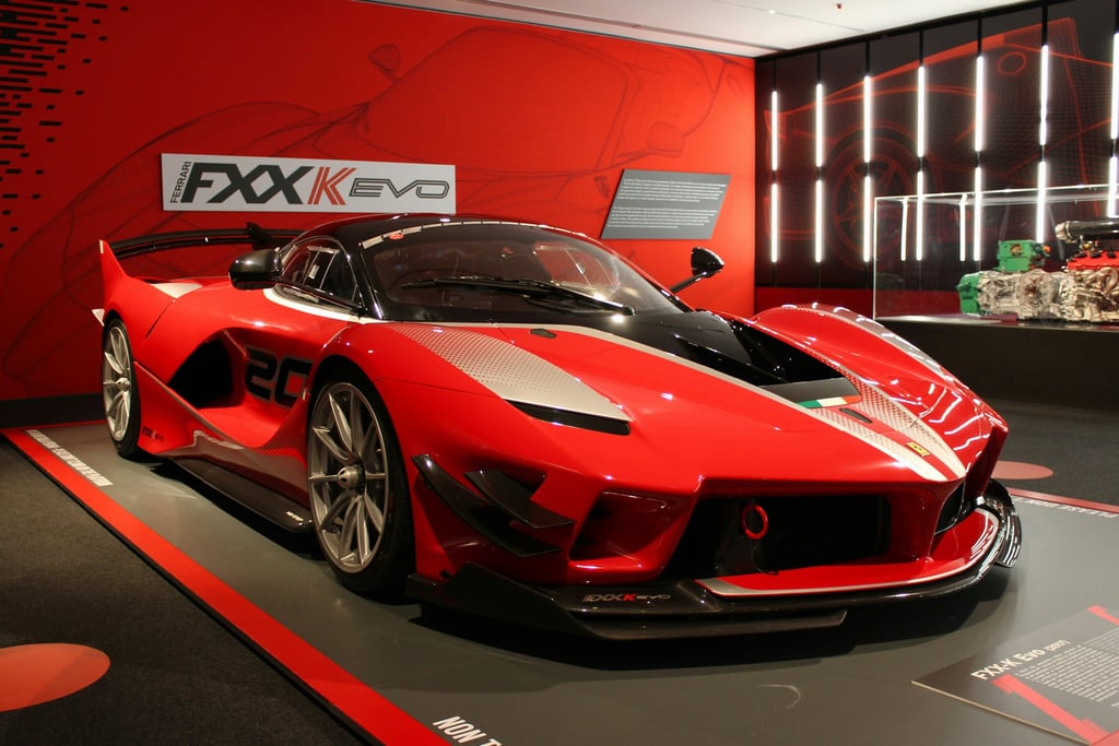 Ferrari FXX-K Evo Exhibition showcasing a stunning red sports car with bold graphics and aggressive design on display.