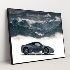 This photo shows a black Ferrari coupe parked in snow with snowy mountains in the background, in a black frame.